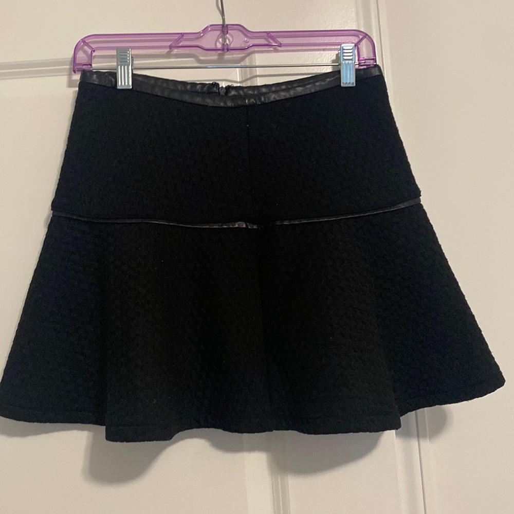 Black skater skirt with a thin leather trim around the middle region